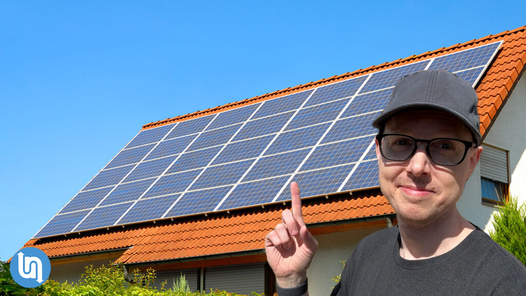 Matt Ferrell pointing at Solar Panels on a roof