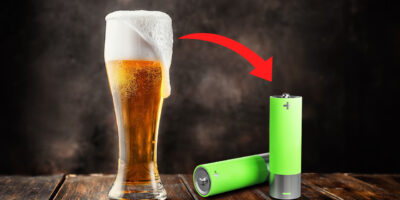 A beer filled glass, with an arrow pointing at some batteries
