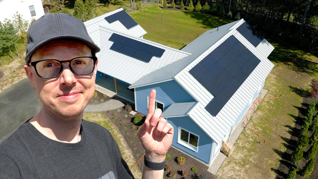 Matt Ferrell pointing at the solar panels on his new house