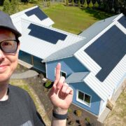 Matt Ferrell pointing at the solar panels on his new house
